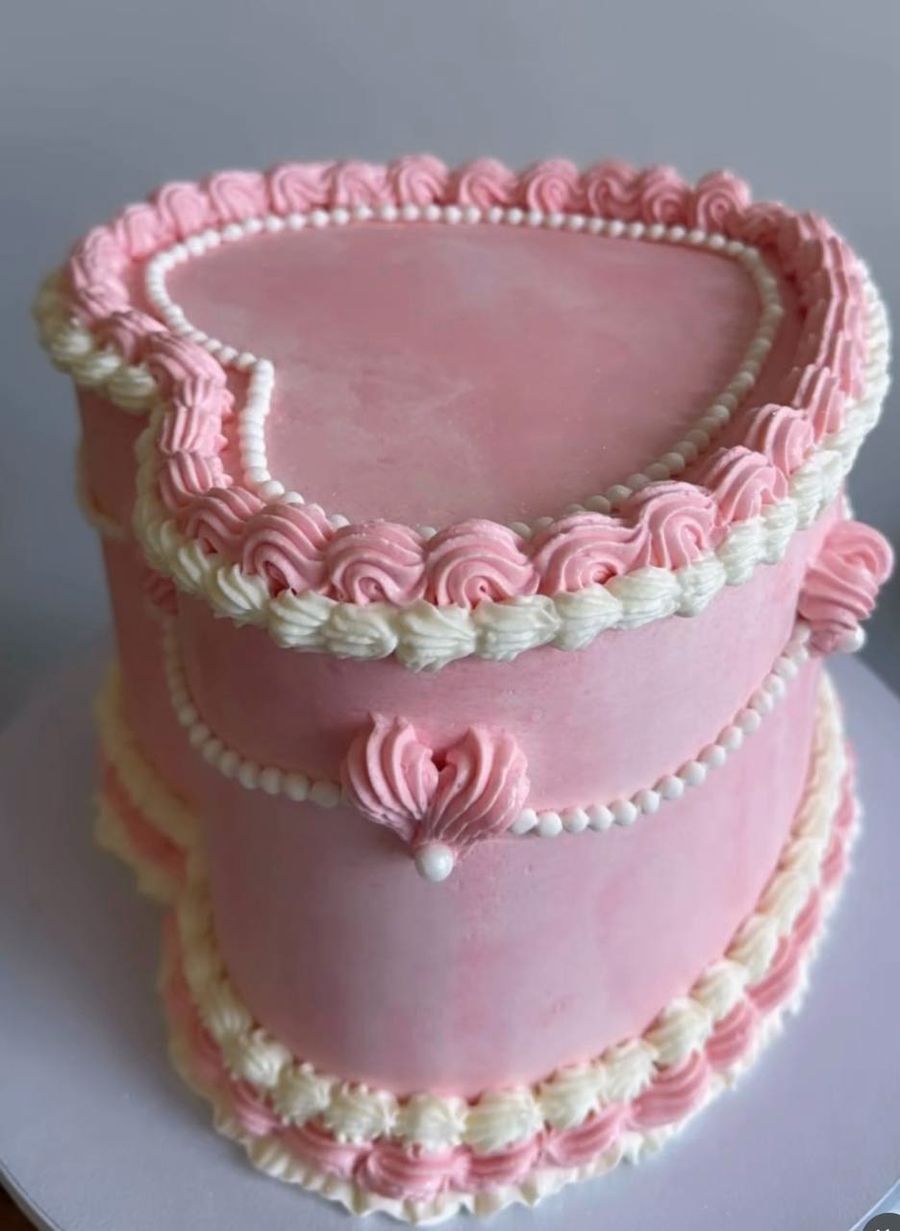 Pink heart-shaped vintage cake with cream piping