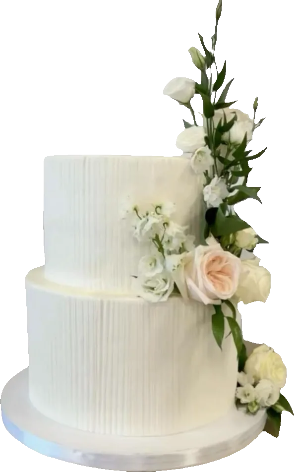 Two-tier textured white wedding cake with fresh roses and greenery